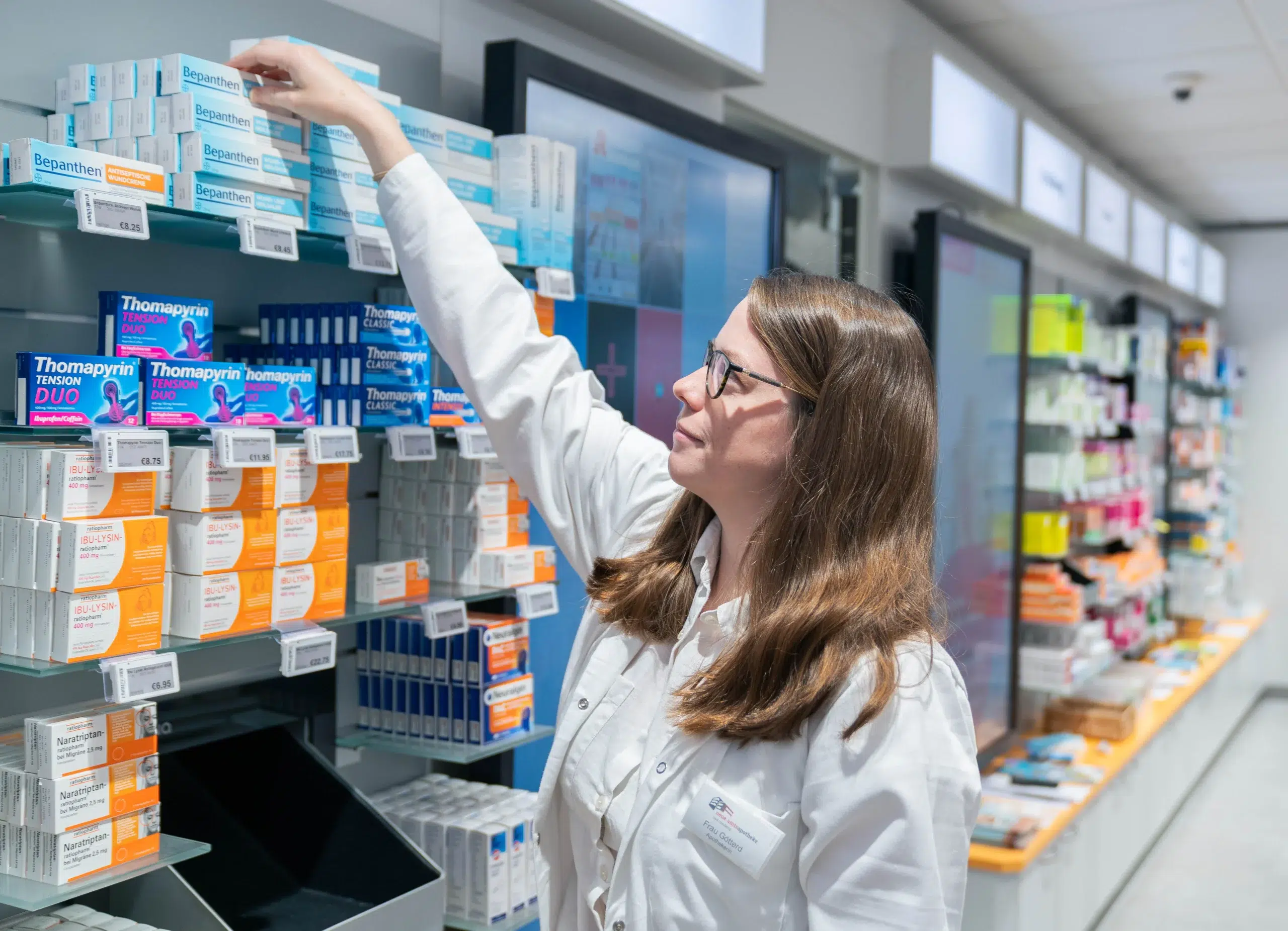 Mit Sorgfalt und Fachwissen wählt die Apothekerin das passende Medikament aus dem Regal.