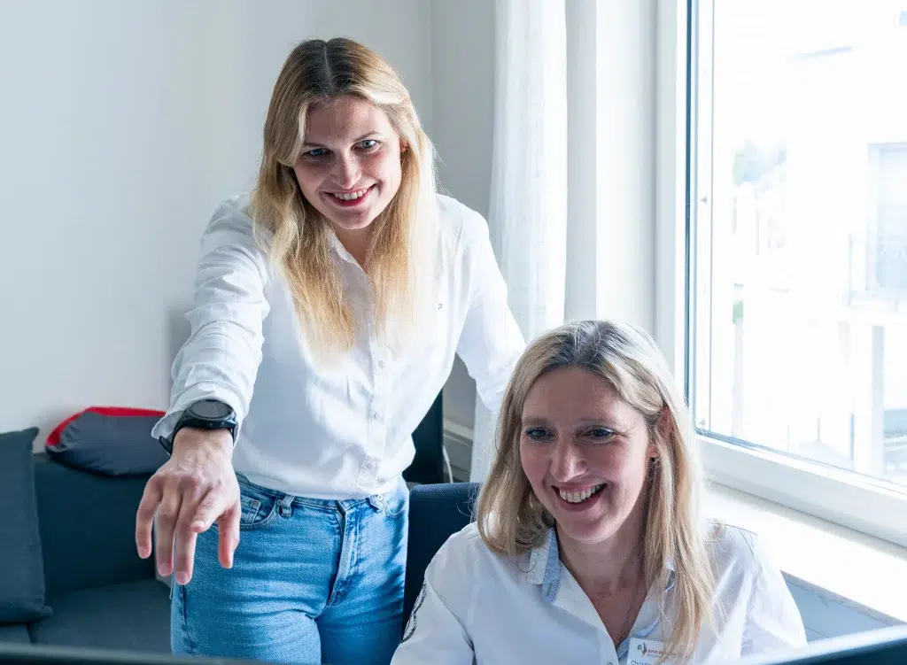 Mitarbeiterinnen der Heimversorgung besprechen digitale Medikationsdaten am PC.