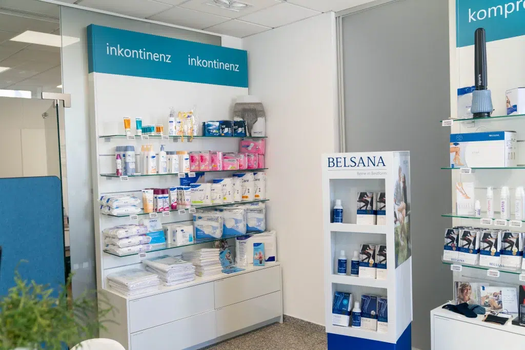 Regal im OranienPflegeShop, ordentlich bestückt mit verschiedenen Inkontinenzprodukten. Die übersichtliche Anordnung ermöglicht eine diskrete und gezielte Auswahl – ein Ausdruck für die bedarfsgerechte Versorgung und das respektvolle Angebot im Pflegebereich.