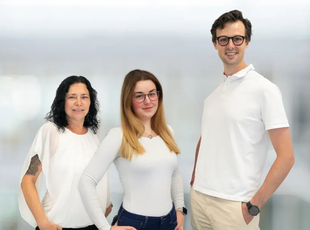 Portrait der Ansprechpartner für die Praxisversorgung bei Gondermann Apotheken: Katja Weichmann, Chiara Krebs und Dr. Marcel Walther stehen nebeneinander und lächeln in die Kamera – kompetent, persönlich, nah