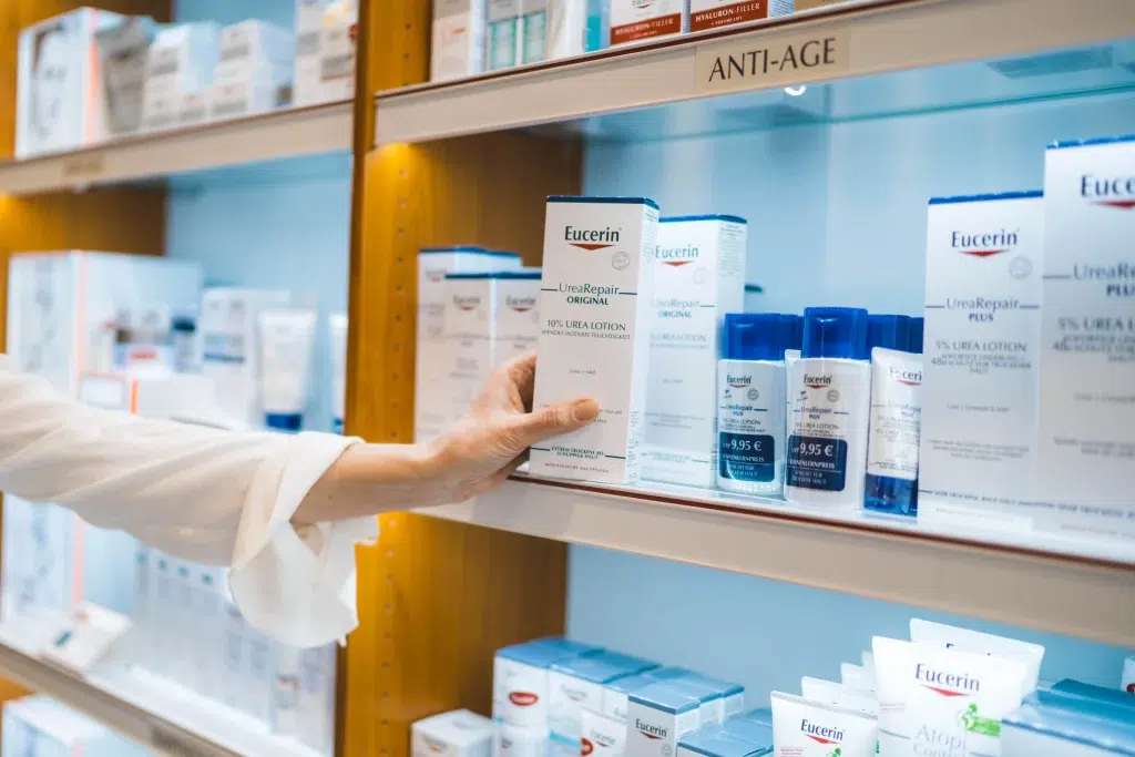 Detailaufnahme: Mitarbeiterin der Gondermann Apotheken hält eine Packung Kompressionsstrümpfe in die Kamera – hochwertige medizinische Versorgung für Venenunterstützung und individuelle Beratung