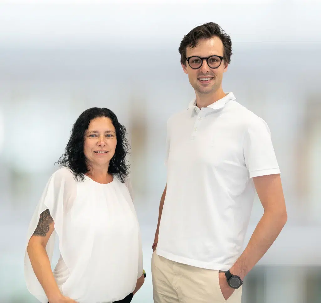 Portrait der Ansprechpartner für die Praxisversorgung bei Gondermann Apotheken: Katja Weichmann und Dr. Marcel Walther stehen nebeneinander und lächeln in die Kamera – kompetent, persönlich, nah